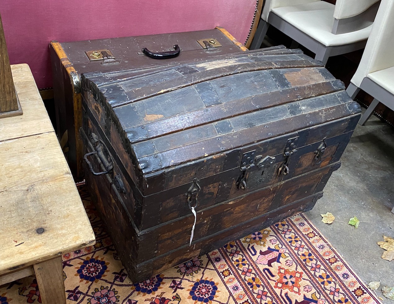 A Victorian wood and iron bound domed trunk, width 78cm, height 54cm, together with a smaller later cabin trunk